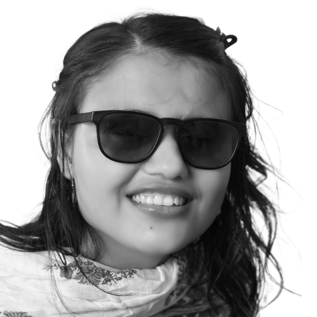 Shilpa Dhungel smiles at the camera. She is a young Nepali woman with tinted glasses and long, dark hair.