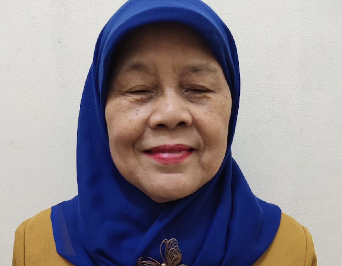 Ariani Soekanwo, seorang wanita Indonesia yang lebih tua mengenakan jilbab biru, tersenyum ke arah kamera.