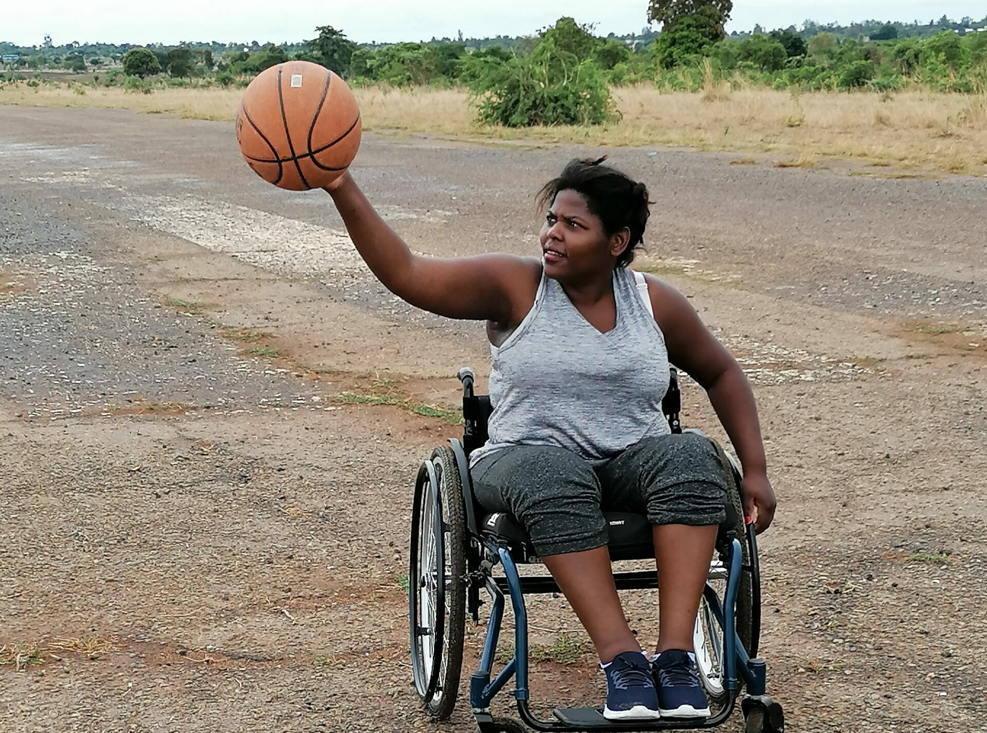 Julie-Marie Chibekete plays basketball in a wheelchair.