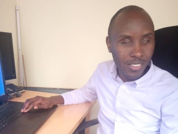 Jean Claude Ngabonziza sits at a table.