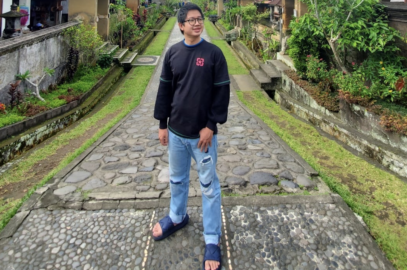 Naufal Asy-Syaddad stands outside homes in Indonesia.