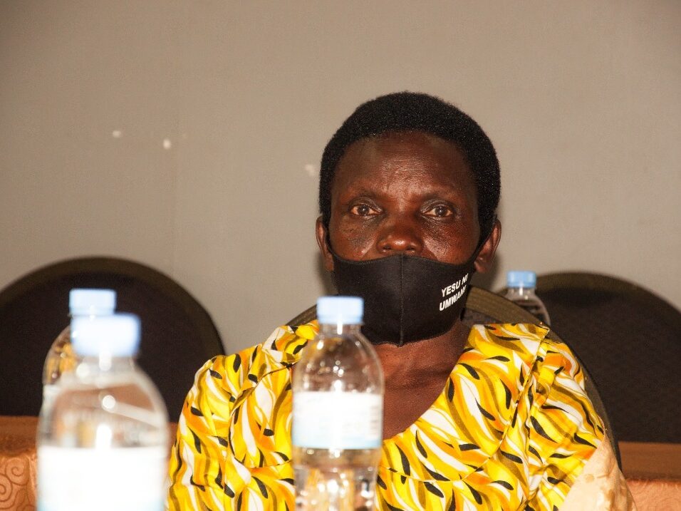 Immacule Mukaruhirwa sits at a table, looking at the camera. 