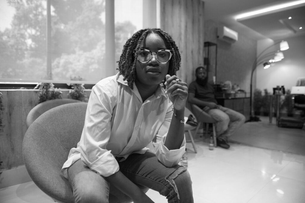 Benedicta Oyedayo Oyewole sits in a chair, looking at the camera.