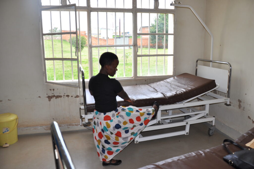 Appoline Buntubwimana attempts to climb on to a hospital bed.
