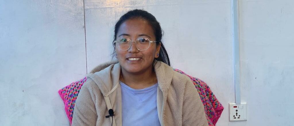 Tsering Palmu Lama, project coordinator at HEAD Nepal, sits in a chair and smiles at the camera.