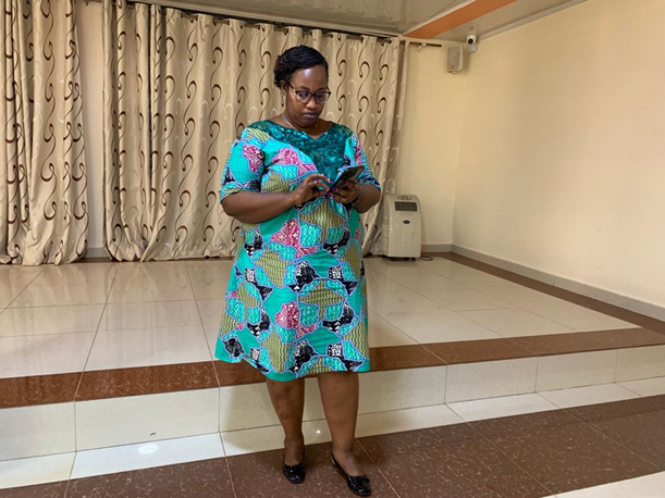 Rose Umetesi, executive director of the National Organization of Users and Survivors of Psychiatry in Rwanda, looks at her phone in a conference room.