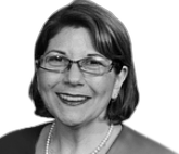 Marcie Roth, a white woman with glasses, smiles at the camera.