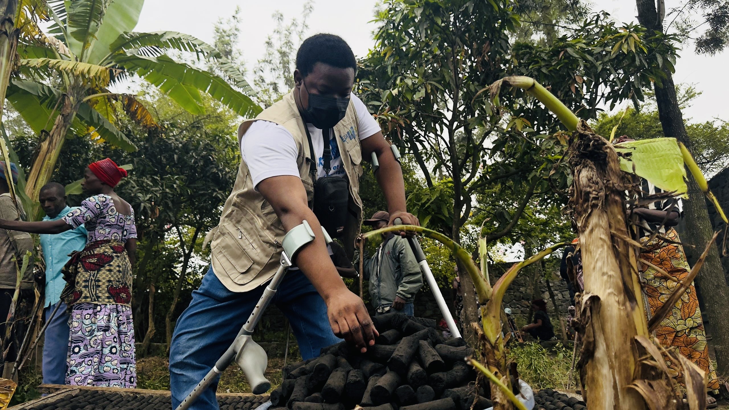 Sylvain Obedi reaches for an ecological briquette from a pile in front of him. He's at a clean cooking event led by the UN Development Programme's Youth4Climate initiative.