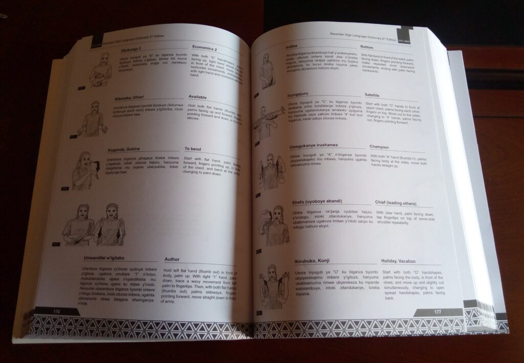 The Rwandan Sign Language Dictionary lies open on a table.
