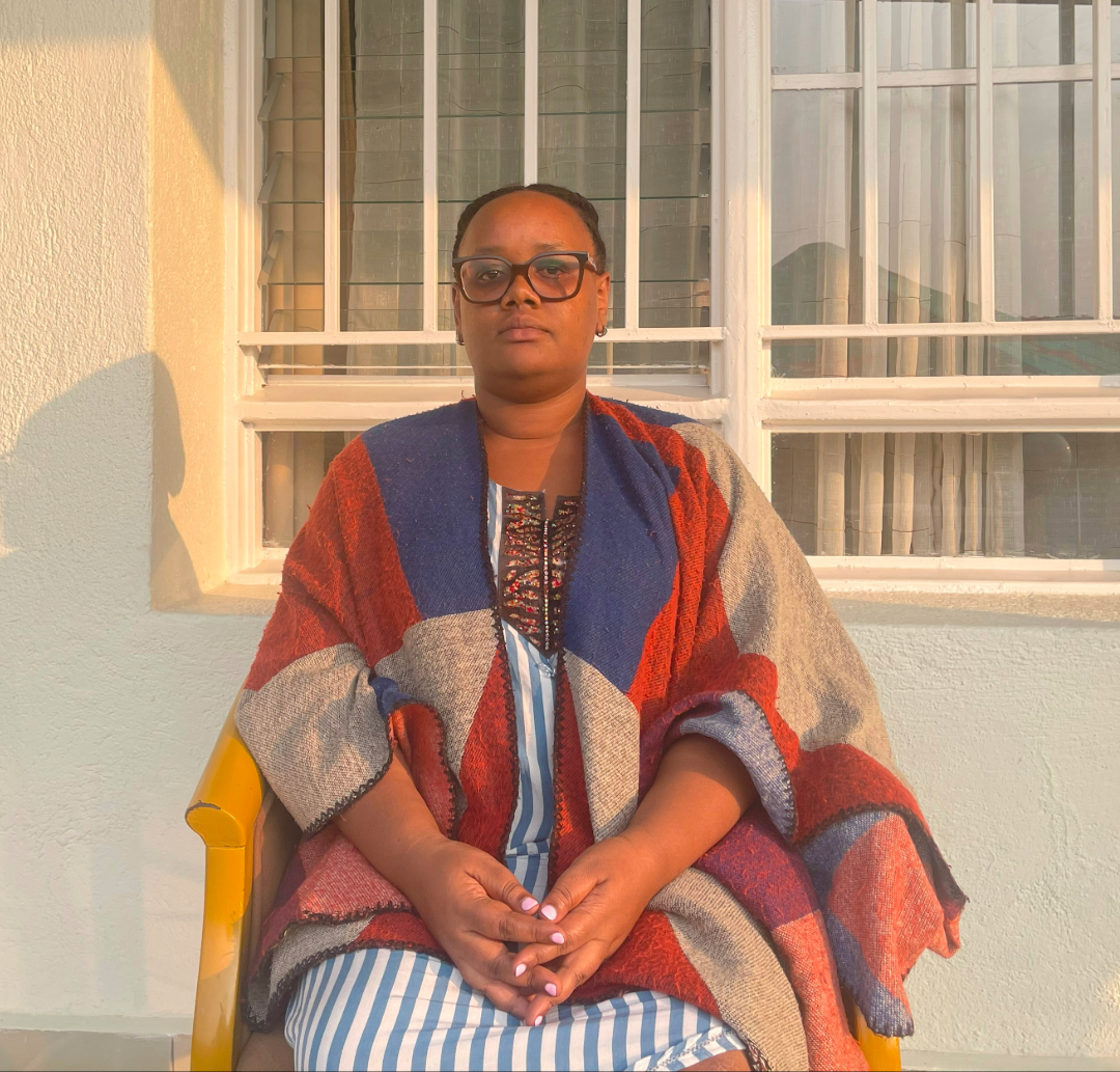 Jannat Umuhoza sits outside wearing dark glasses.