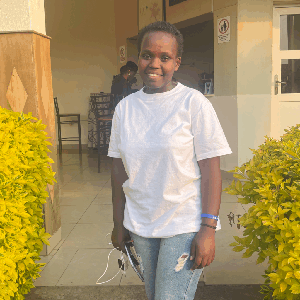 Kevine Niyokwizerwa smiles at the camera outside a home.