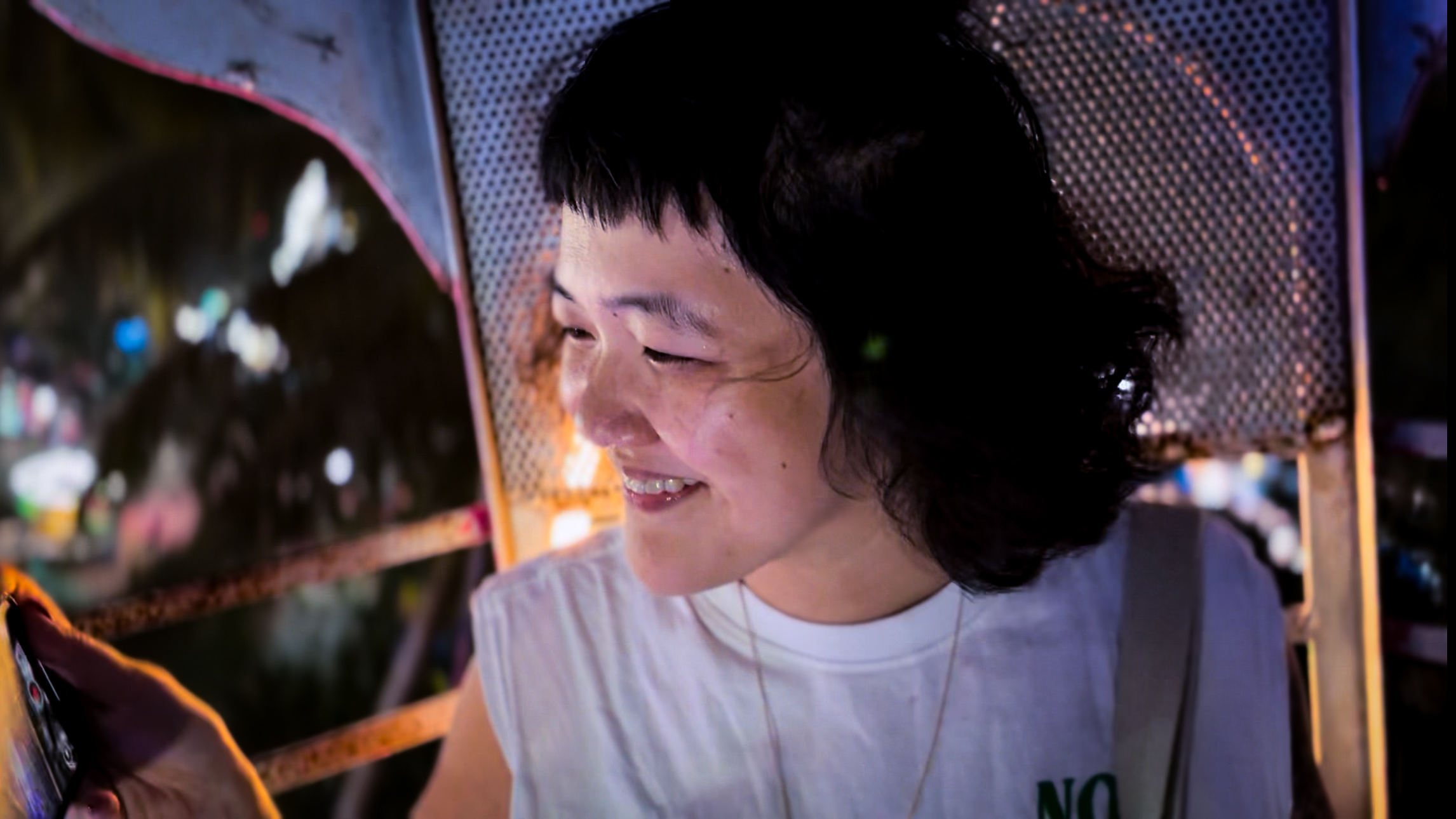 Beatrice Leong films something on her iPhone and smiles.