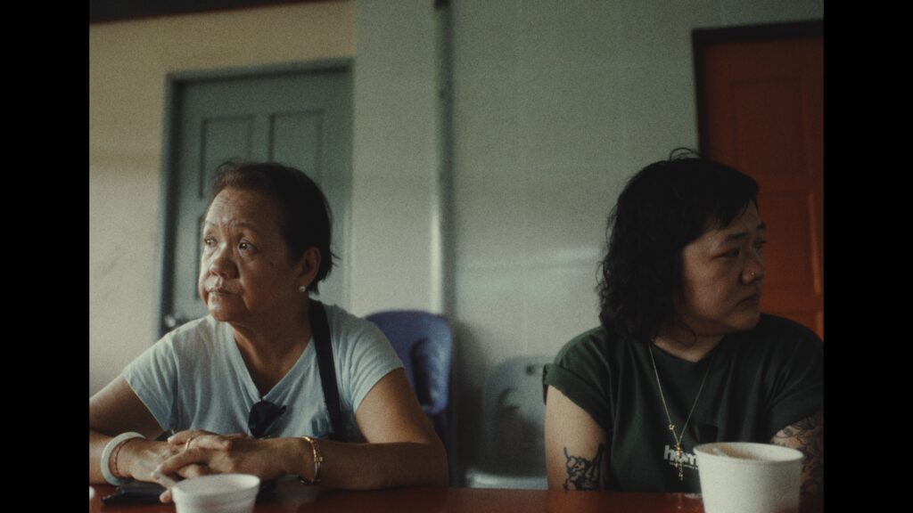 Beatrice sits with her mother inside a restaurant. She looks upset while her mother seems to be ignoring her.