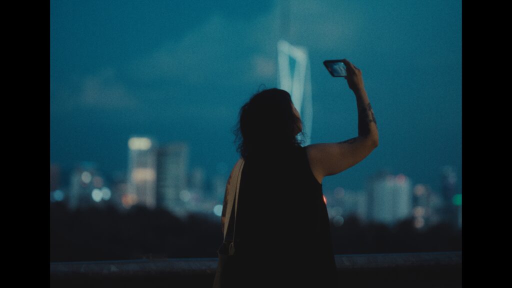Bea Leong holds her iPhone toward the night sky and films.