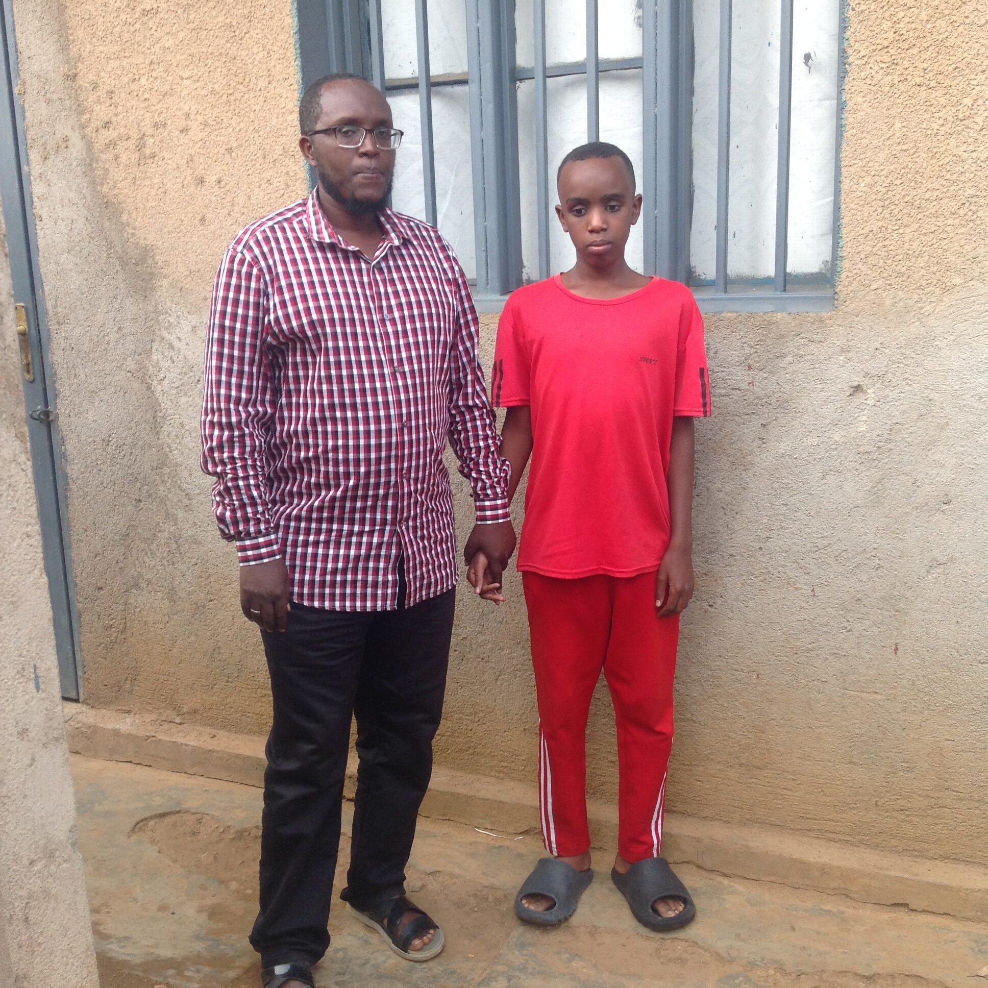 Saifi Qudra stands outside with his father.