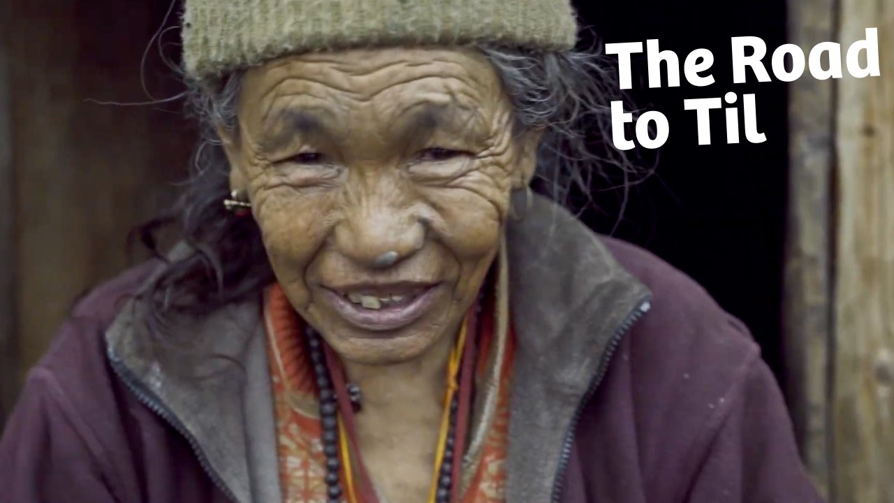 Thumbail for The Road to Til. It includes the title and a photo of an elderly woman looking into the camera.