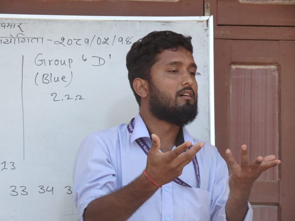 Deaf advocate Ghan Bahadur Thapa gestures in front of a white board.