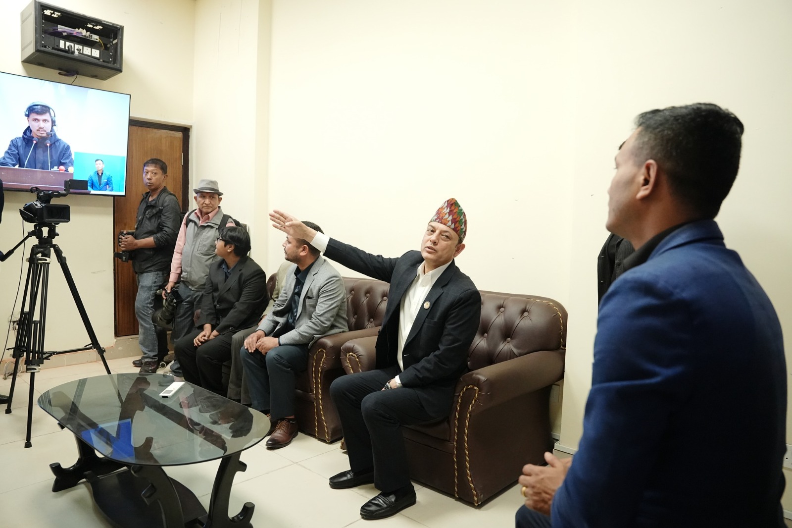 Nepal House Speaker Dol Prasad (D.P.) Aryal points to a television set with an interpreter on the screen.