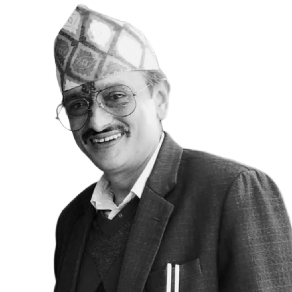 Bishnu Acharya smiles into the camera. He is a middle-aged Nepali man with a mustache, glasses, and a hat over a bindi on his forehead.