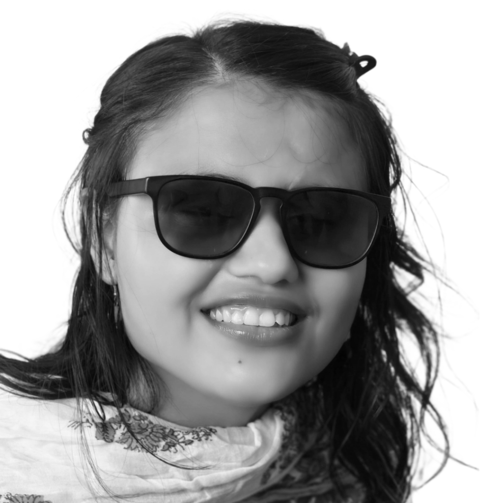 Shilpa Dhungel smiles at the camera. She is a young Nepali woman with tinted glasses and long, dark hair.