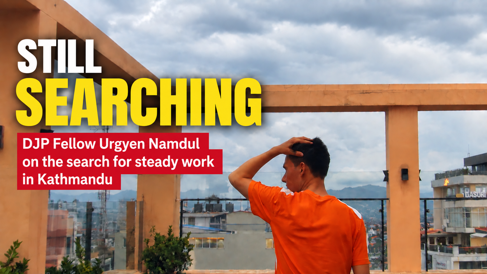 Thumbnail for Still Searching showing DJP Fellow Urgyen Namdul standing on a rooftop overlooking Kathmandu, with one hand resting on his head. Large text reads “Still Searching,” with a subhead about his search for steady work.